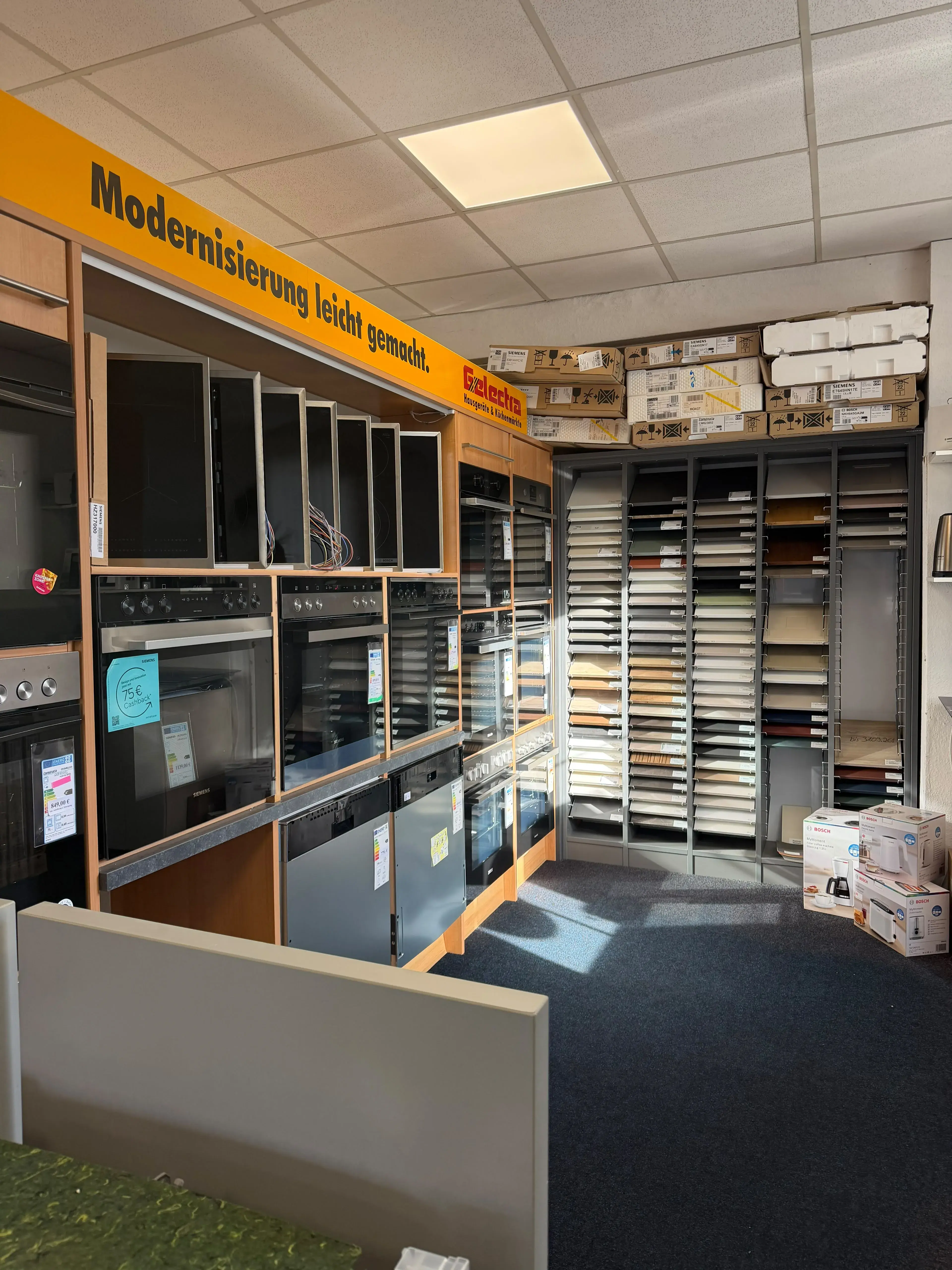 Ausstellung von Einbauöfen & Farbmustern in einem Küchenstudio.